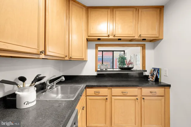 a kitchen with stainless steel appliances granite countertop a sink and a refrigerator