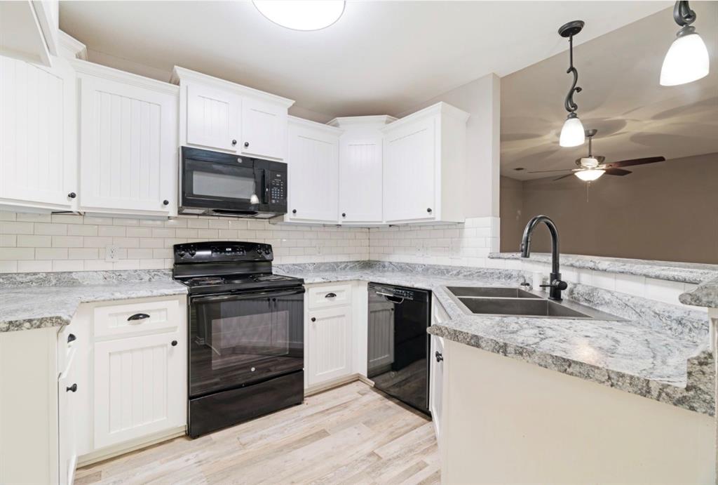 90 44th Street Southwest Paris, TX 75460 - Photo 6 of 17 a kitchen with kitchen island granite countertop a sink stainless steel appliances and white cabinets