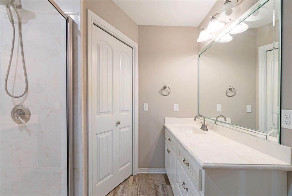 90 44th Street Southwest Paris, TX 75460 - Photo 10 of 17 a bathroom with a double vanity sink a mirror and a shower