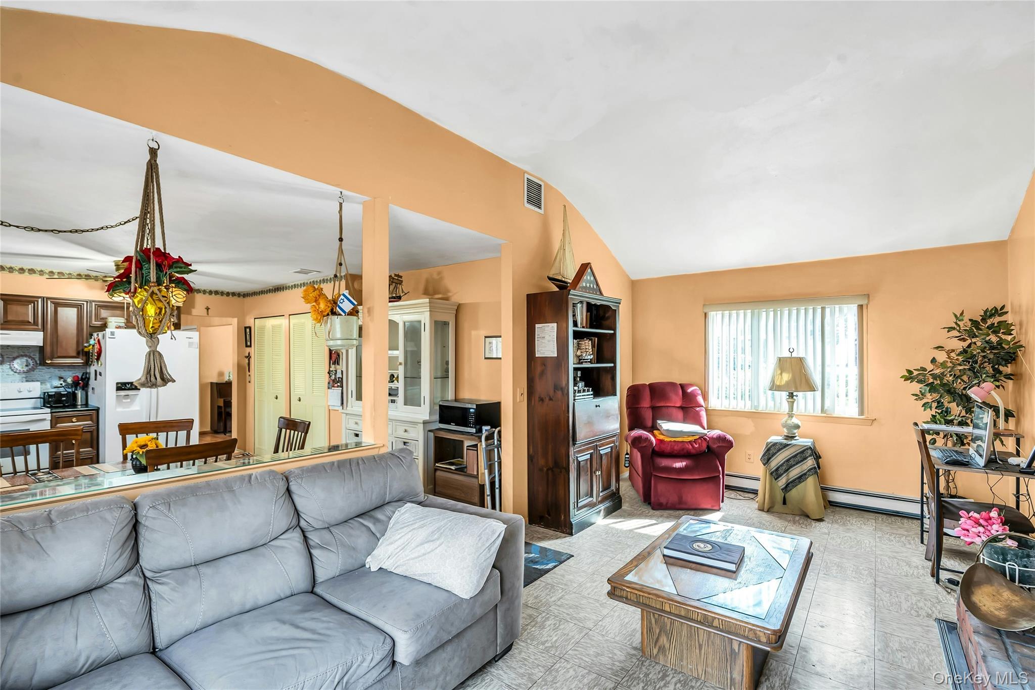 7 Hastings Drive Ridge, NY 11961 - Photo 11 of 33 a living room with furniture a flat screen tv and a floor to ceiling window