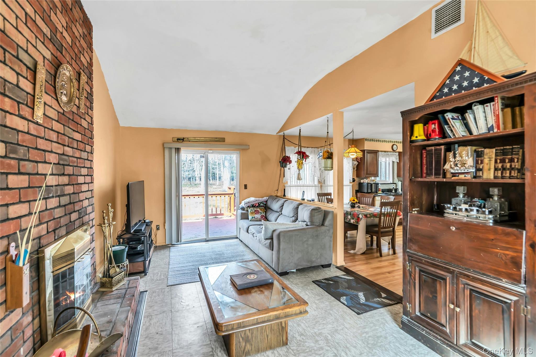7 Hastings Drive Ridge, NY 11961 - Photo 6 of 33 a living room with furniture a flat screen tv and a floor to ceiling window
