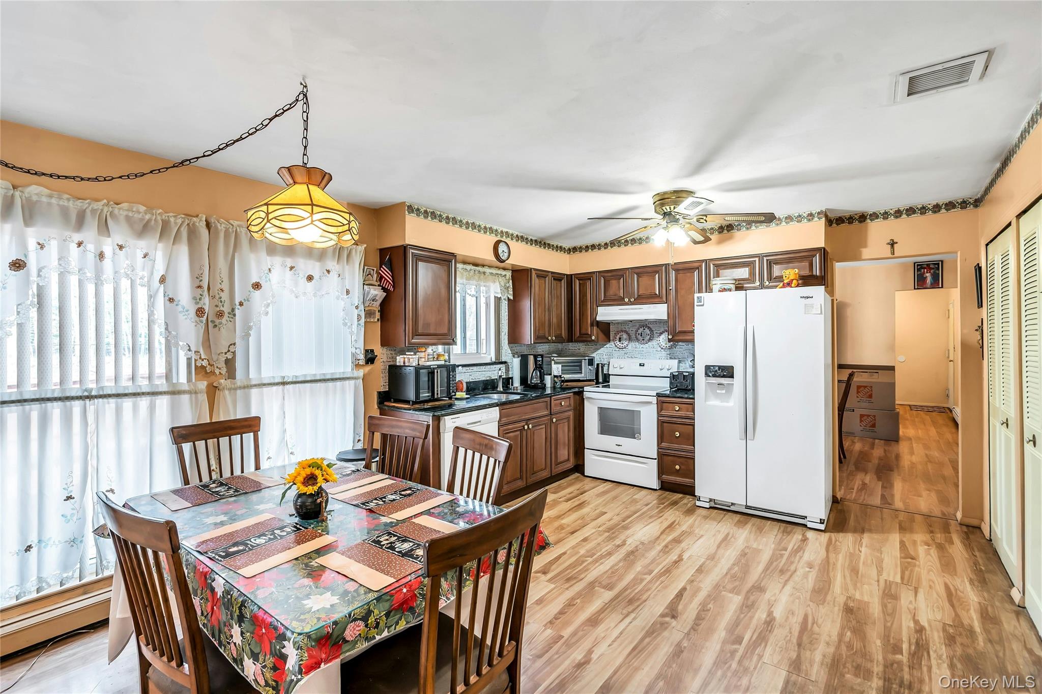 7 Hastings Drive Ridge, NY 11961 - Photo 8 of 33 a open kitchen with stainless steel appliances granite countertop a stove a refrigerator a oven a dining table and chairs with the wooden floor