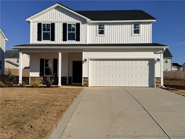 a front view of a house with yard and garage