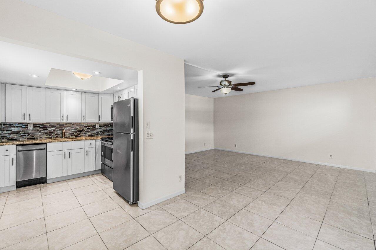 641 Normandy Lane, Unit N Delray Beach, FL 33484 - Photo 2 of 26 a kitchen with a refrigerator a stove top oven and cabinets