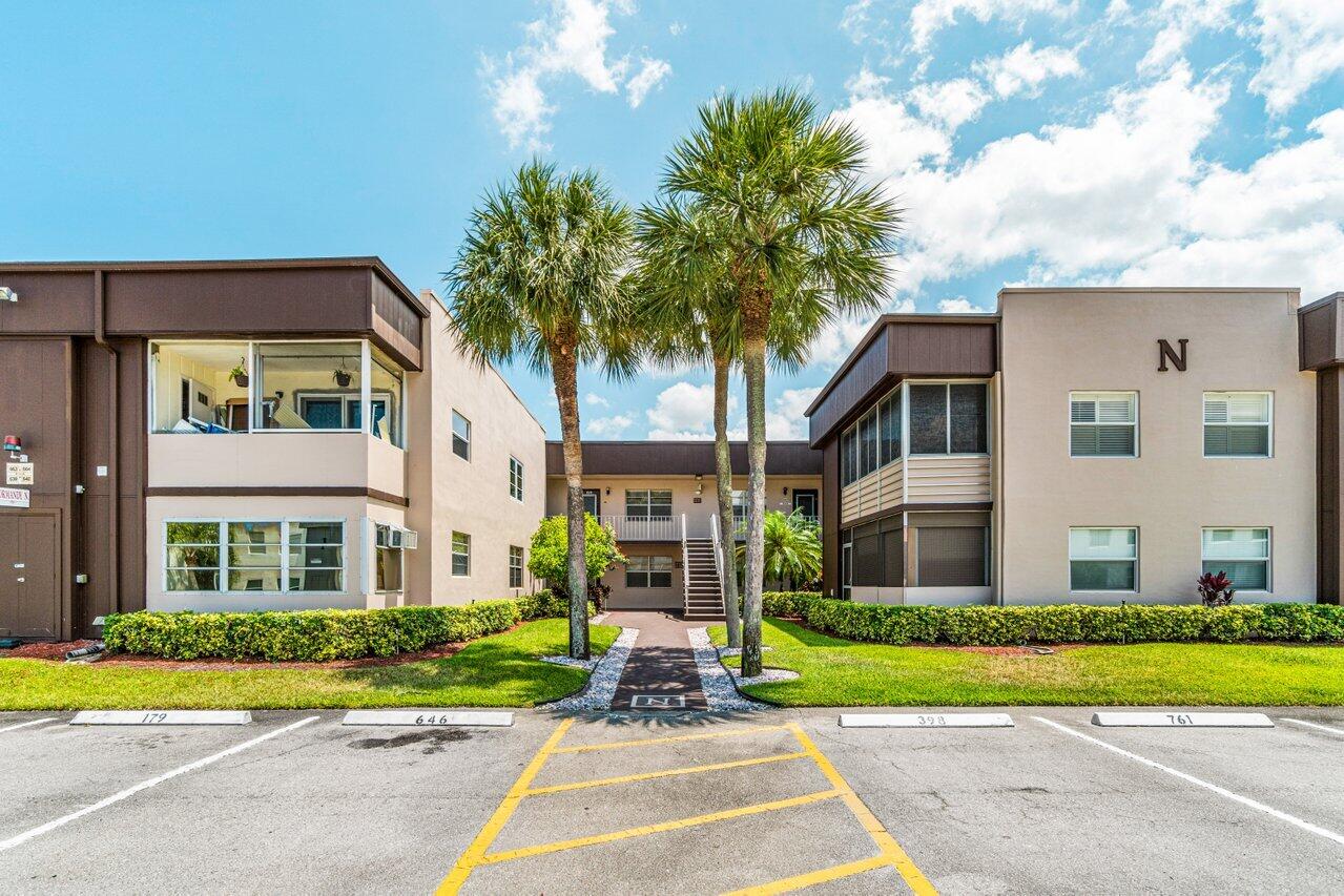 641 Normandy Lane, Unit N Delray Beach, FL 33484 - Photo 22 of 26 a front view of a house with garden and porch