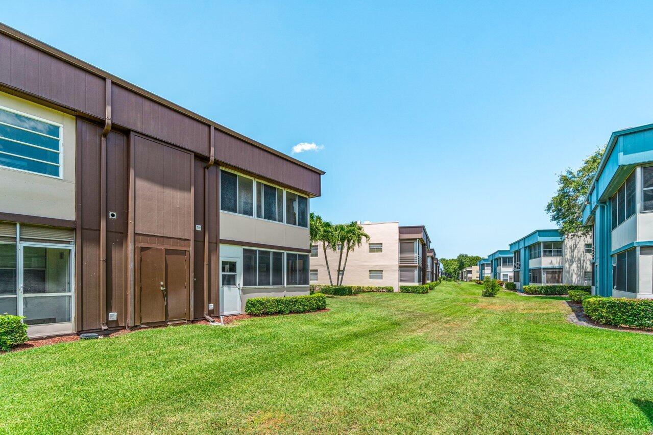 641 Normandy Lane, Unit N Delray Beach, FL 33484 - Photo 23 of 26 a view of an house with backyard porch and garden