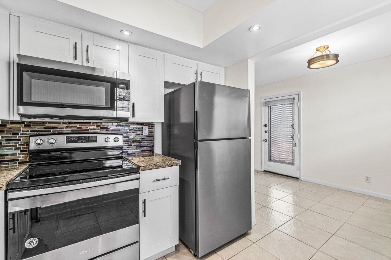 641 Normandy Lane, Unit N Delray Beach, FL 33484 - Photo 5 of 26 a kitchen with appliances and cabinets