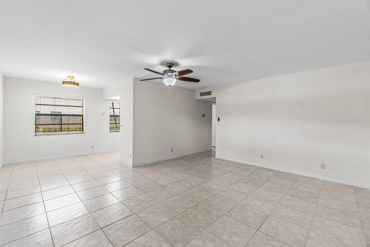 641 Normandy Lane, Unit N Delray Beach, FL 33484 - Photo 7 of 26 an empty room with windows and chandelier fan