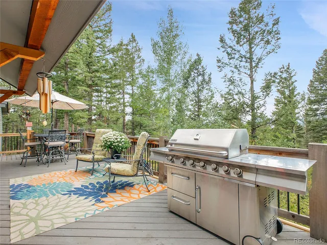 a view of a patio with table and chairs with wooden floor and fence