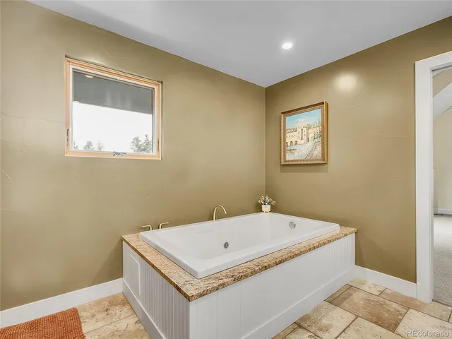 a bathroom with a tub and a window