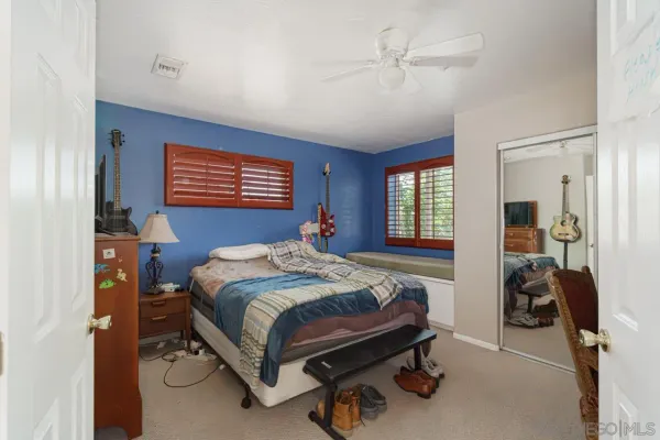 an empty room with a window and a ceiling fan