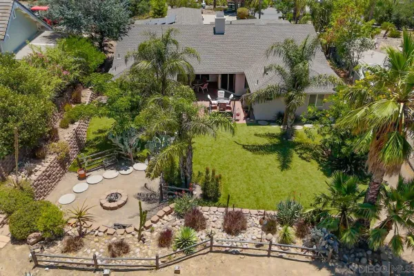 a view of a house with backyard and sitting area
