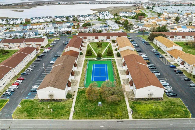 an aerial view of residential houses with outdoor space and parking