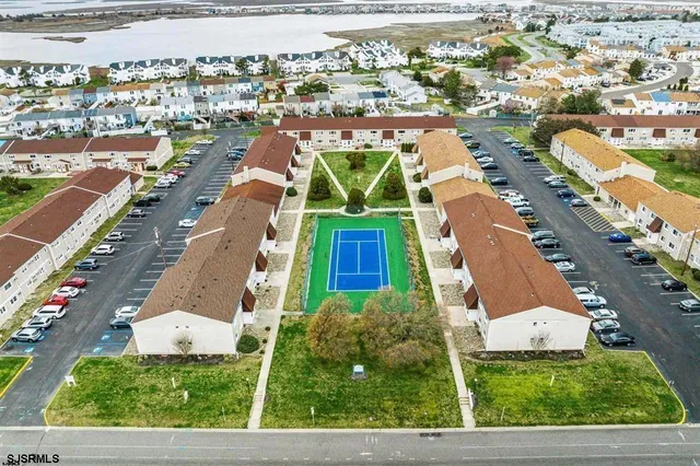 an aerial view of residential houses with outdoor space and parking