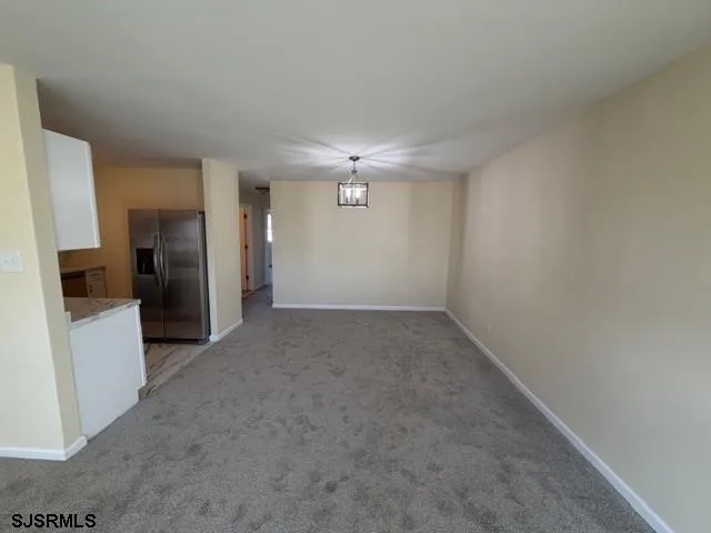 a view of an empty room with a kitchen