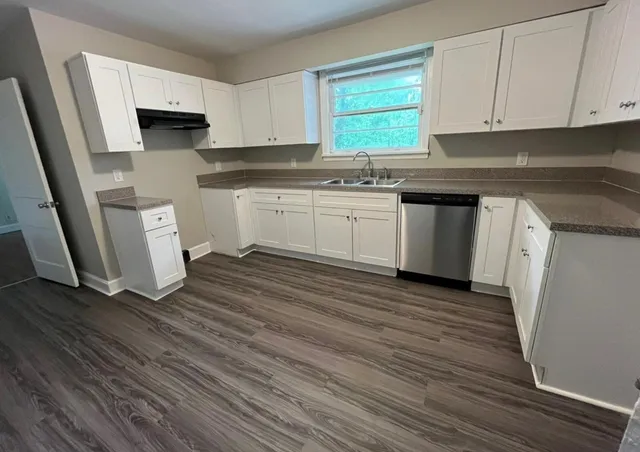 a kitchen with a sink a stove and cabinets