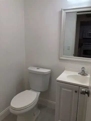 a bathroom with a toilet sink and mirror
