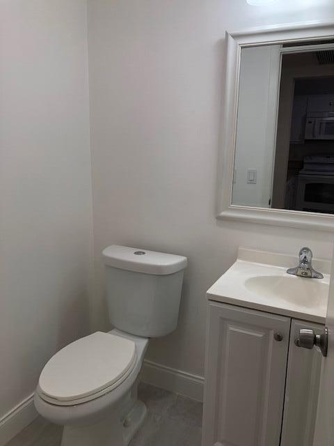 9273 Southwest 8th Street, Unit 417 Boca Raton, FL 33428 - Photo 11 of 25 a bathroom with a toilet sink and mirror