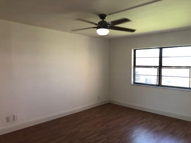 9273 Southwest 8th Street, Unit 417 Boca Raton, FL 33428 - Photo 12 of 25 an empty room with wooden floor and windows
