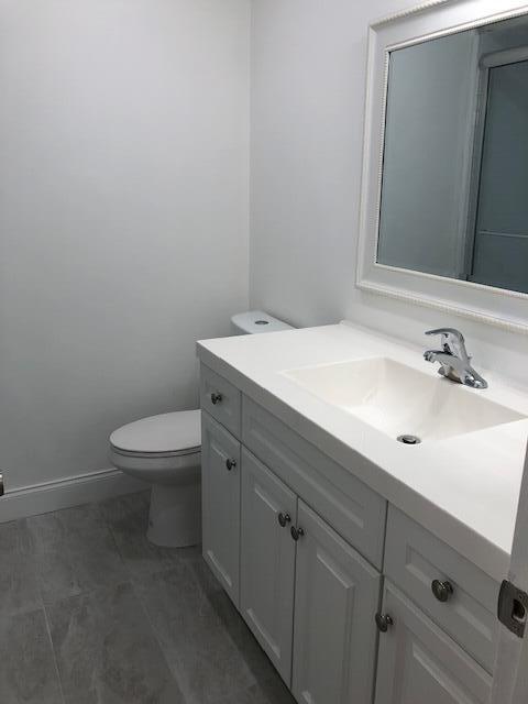 9273 Southwest 8th Street, Unit 417 Boca Raton, FL 33428 - Photo 16 of 25 a bathroom with a sink a toilet and mirror