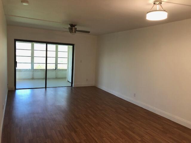 9273 Southwest 8th Street, Unit 417 Boca Raton, FL 33428 - Photo 8 of 25 a view of an empty room with wooden floor and a window