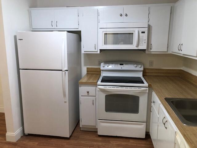 9273 Southwest 8th Street, Unit 417 Boca Raton, FL 33428 - Photo 9 of 25 a white refrigerator freezer and a stove sitting inside of a kitchen