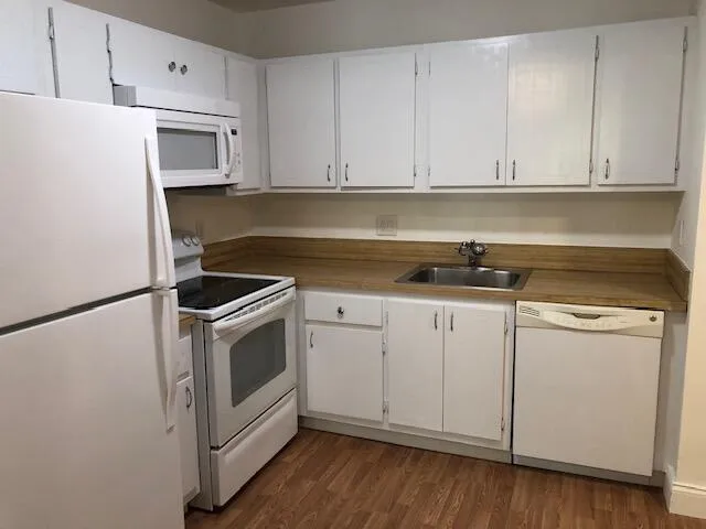 a kitchen with white cabinets and white appliances