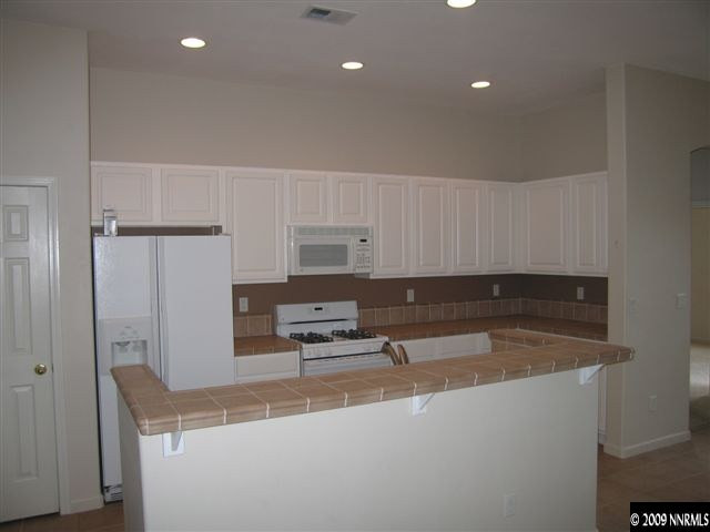 1681 Dutch Ravine Court Reno, NV 89521 - Photo 3 of 9 a kitchen with kitchen island a sink stainless steel appliances and cabinets