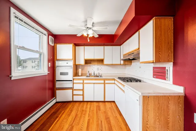 a kitchen with stainless steel appliances a sink cabinets and a window