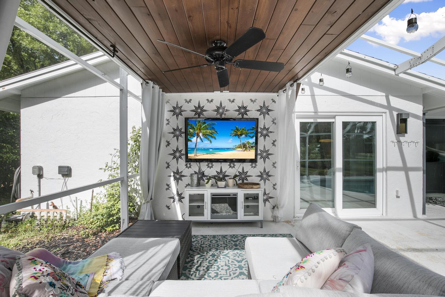 149 Big Springs Drive Naples, FL 34113 - Photo 24 of 35 a living room with couches a flat screen tv and a table with garden view
