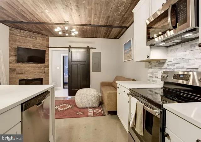 a kitchen that has a sink a stove and a microwave
