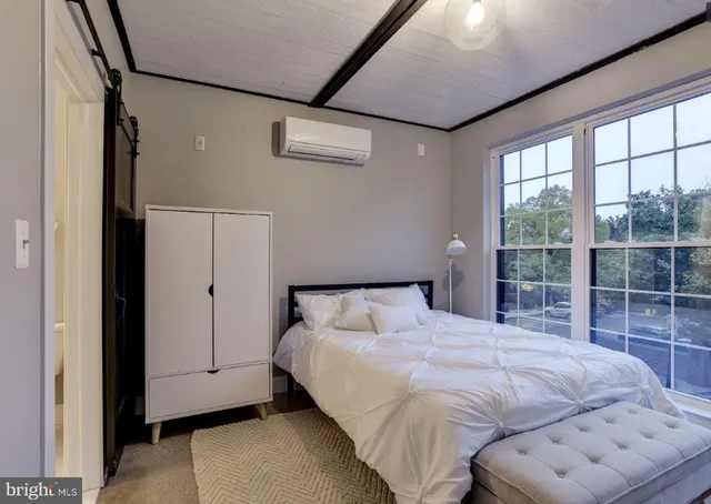 a bedroom with a bed and a large window