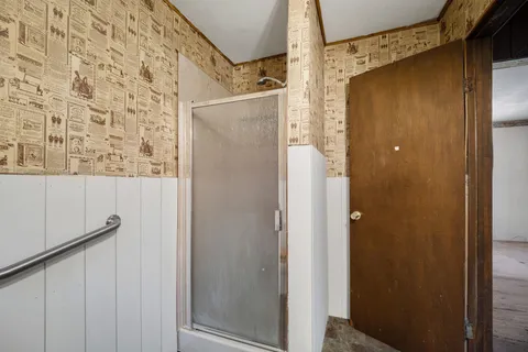 a bathroom with a shower and a mirror