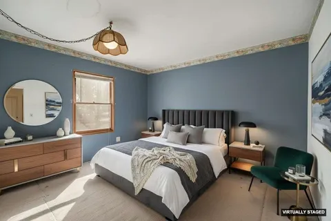 a bedroom with a bed window and a mirror