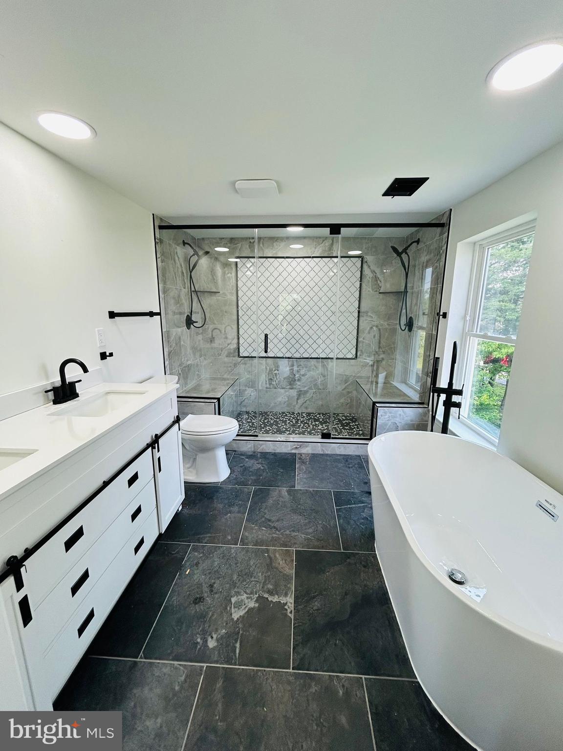 9647 Liberty Road Frederick, MD 21701 - Photo 11 of 14 a bathroom with a double vanity sink a toilet and bathtub