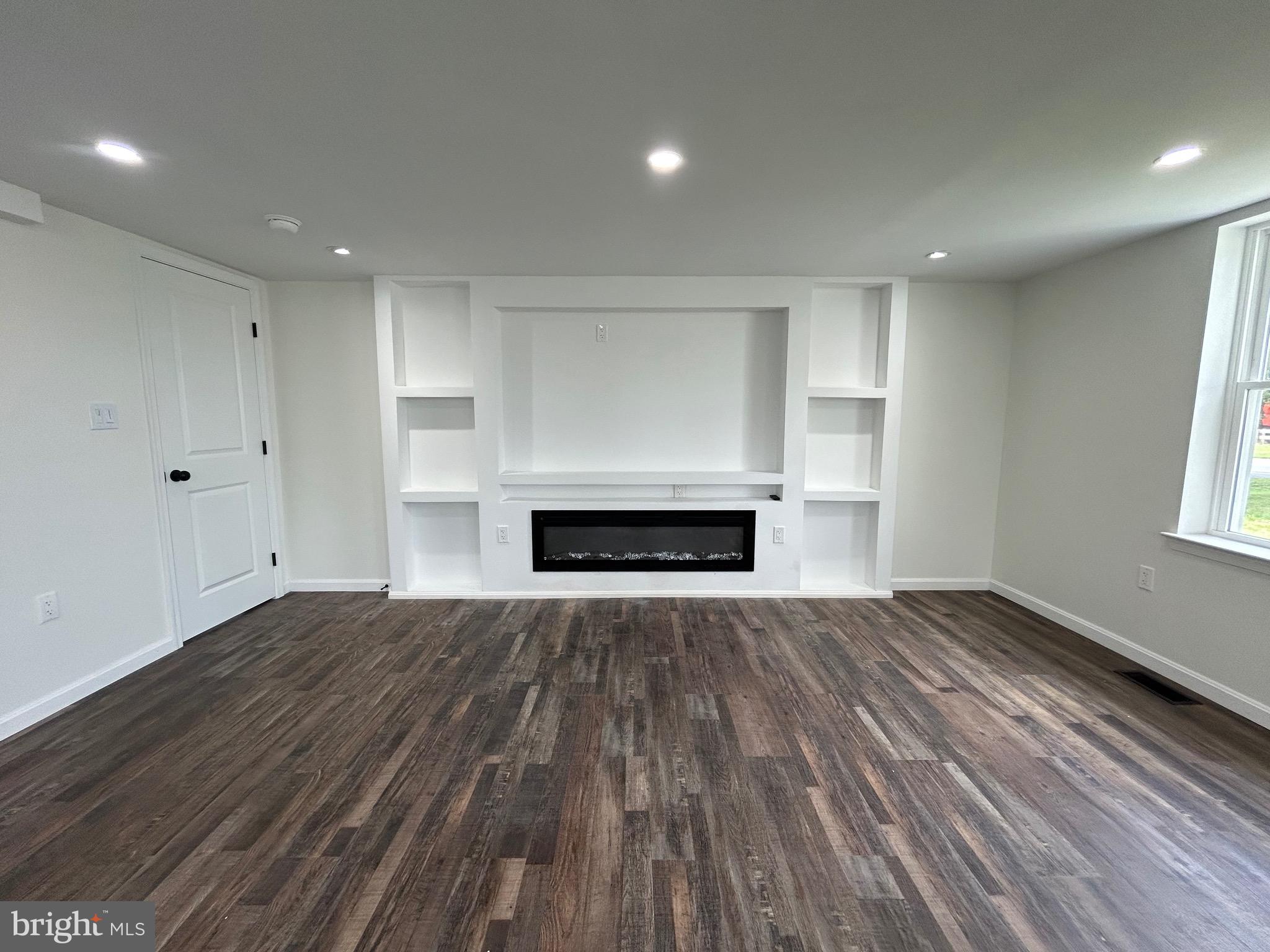 9647 Liberty Road Frederick, MD 21701 - Photo 3 of 14 a view of empty room with wooden floor and fireplace
