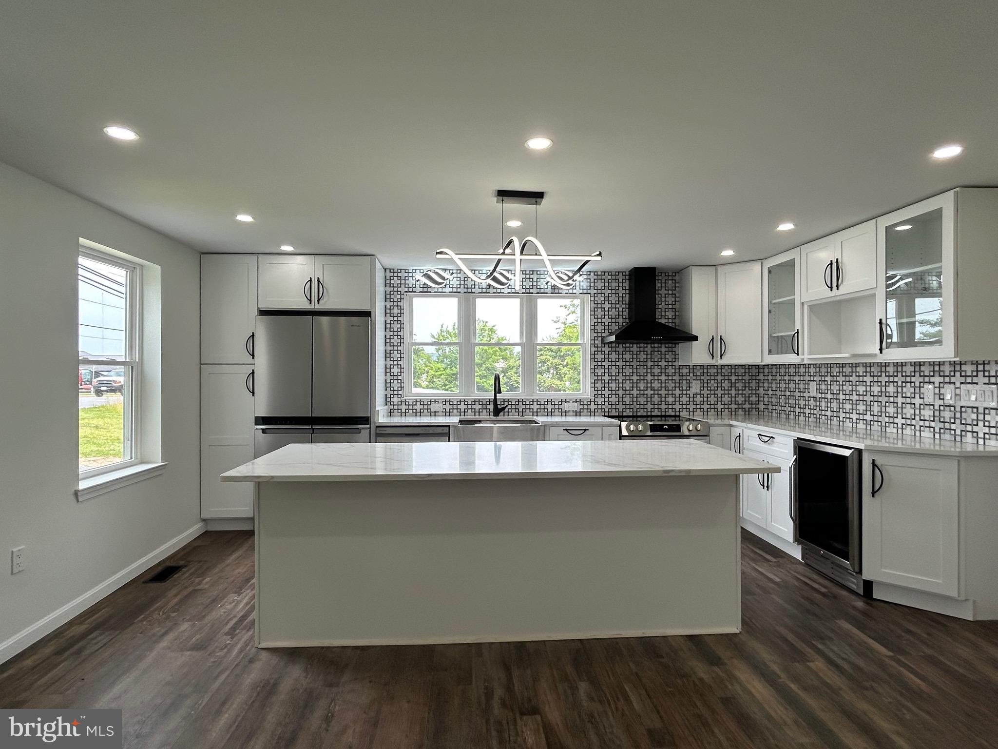 9647 Liberty Road Frederick, MD 21701 - Photo 4 of 14 a kitchen with kitchen island granite countertop a stove top oven a sink dishwasher and white cabinets with wooden floor