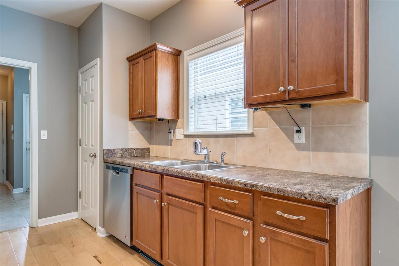 1448 Island Town Cove Memphis, TN 38103 - Photo 6 of 18 a kitchen with granite countertop cabinets sink and window