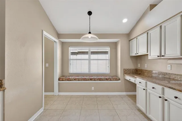 a view of a kitchen with granite countertop white cabinets and a wooden floor