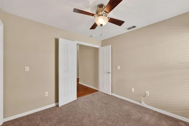 an empty room with a ceiling fan and a window