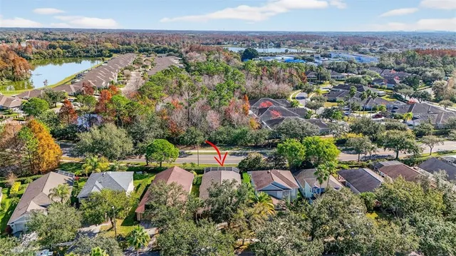 an aerial view of a houses with a yard and lake view