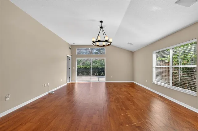 a view of wooden floor chandelier and windows in a room