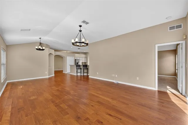 a view of a livingroom with a furniture wooden floor and chandelier