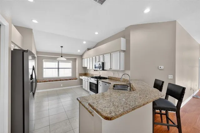 a kitchen with a counter top space appliances and cabinets