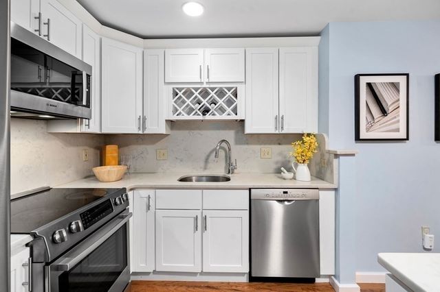 an empty room with kitchen and windows