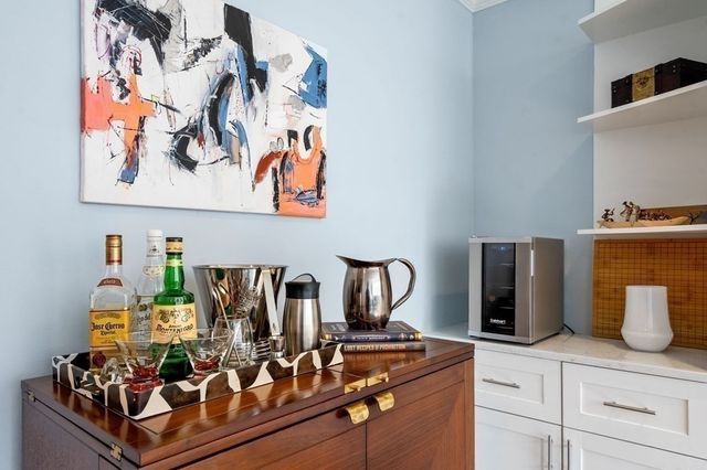 a kitchen with stainless steel appliances a refrigerator a stove a sink dishwasher and white cabinets with wooden floor