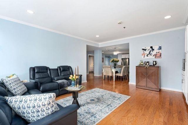 a bedroom with a bed a dresser and a chandelier