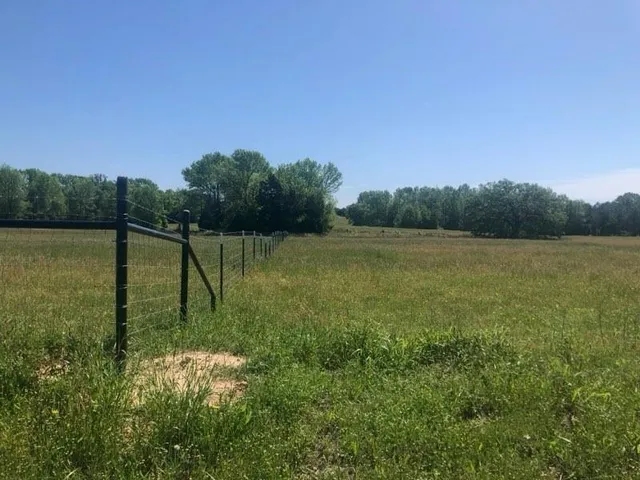 a view of a field with a lake in the background
