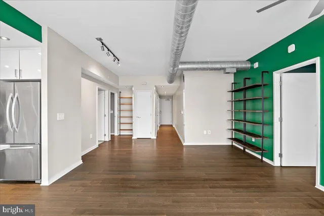 a view of empty room with wooden floor and window