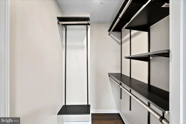 an empty room with wooden floor and a ceiling fan